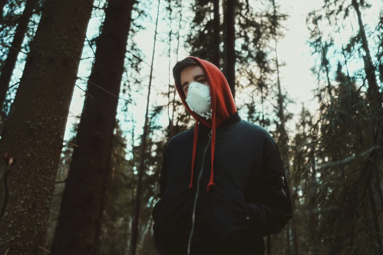a person wearing a mask standing in a forest