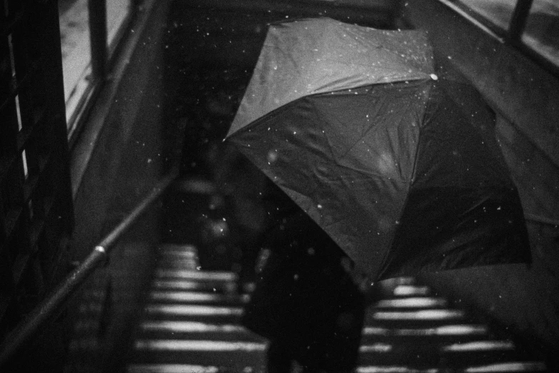 the umbrella is on a stairway as it rains