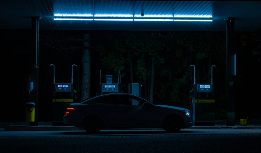 the car is parked on the side of the road at night