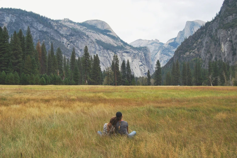 a woman is sitting in the tall grass