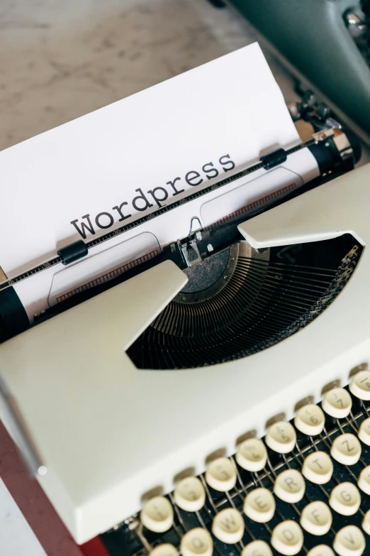 a vintage typewriter sitting next to a paper that says wordpress