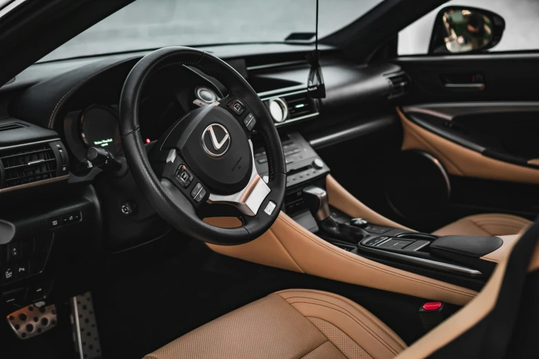 the inside of a vehicle showing the dashboard and tan leather trim