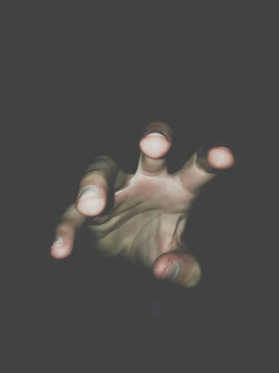 a hand holding onto soing in a dark room