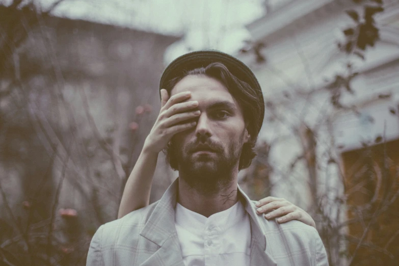 a man with a hat covering his face