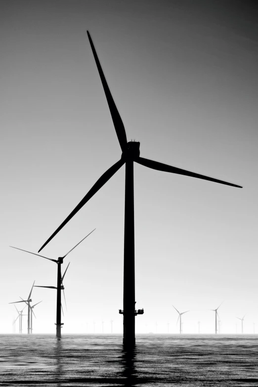 several windmills sitting on top of a hill in the water