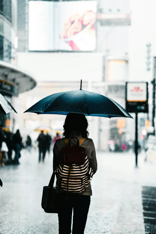 a person walking down a street while holding an umbrella