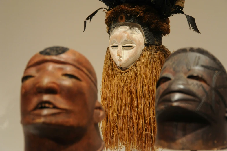 an elaborate mask with hair between other masks