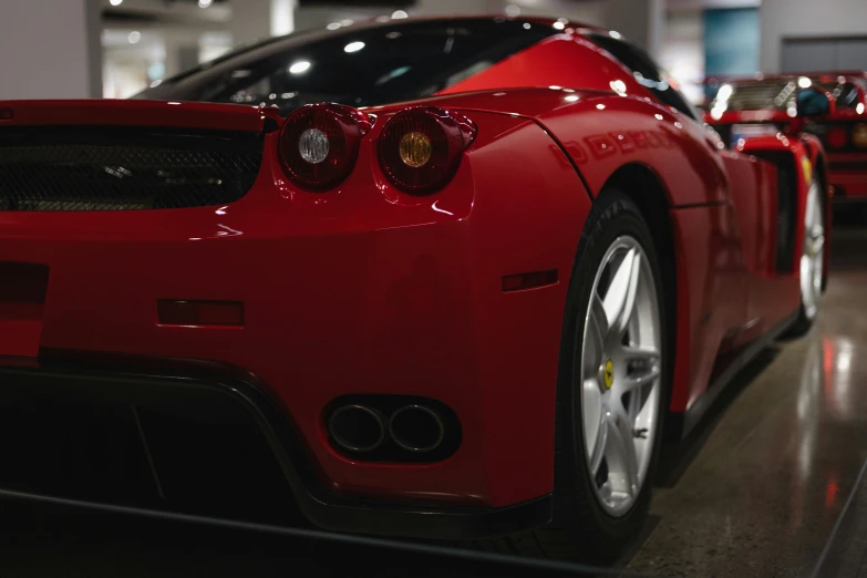 a red ferrari is parked in a showroom
