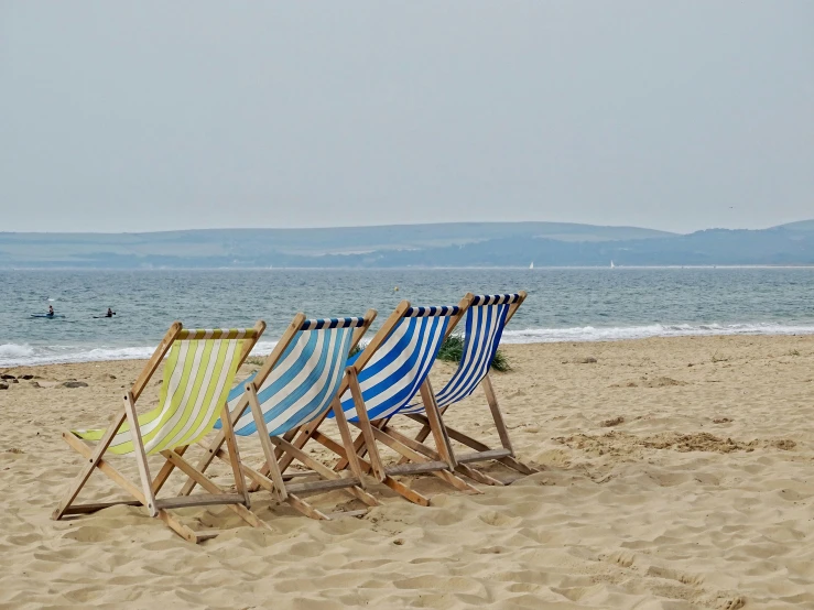 two empty lawn chairs are left on the beach