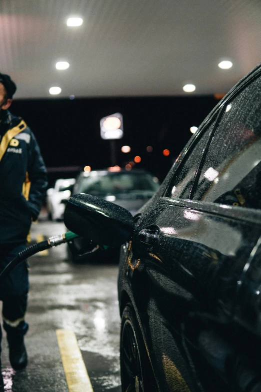 a man with a hose hooked up to a car