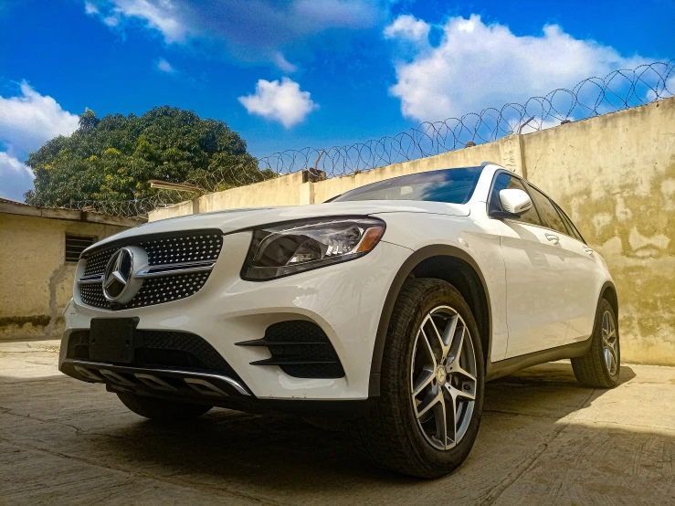 a white mercedes benz vehicle parked in front of a wall