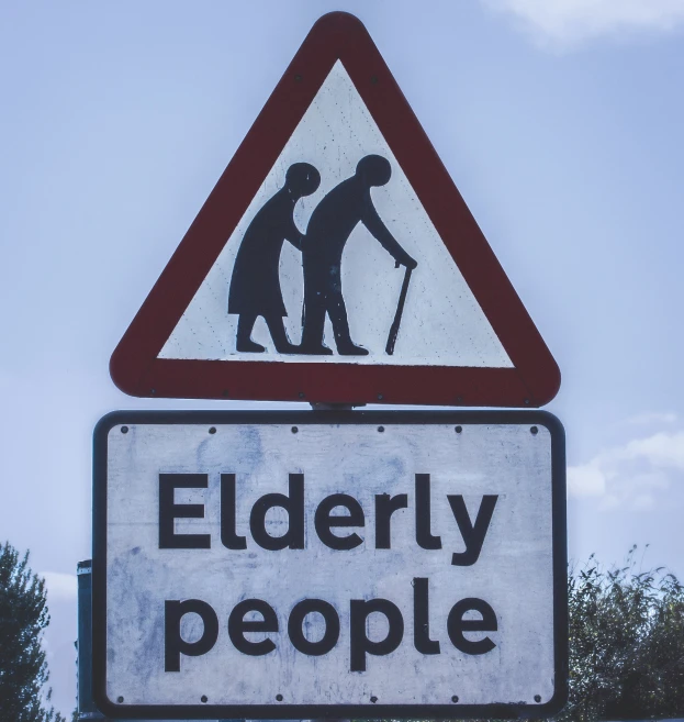 a road sign warns that elderly people can cross the street