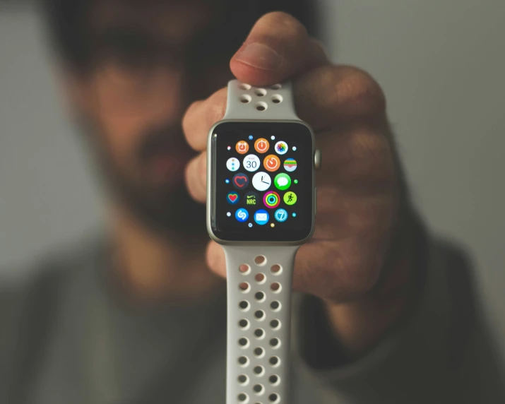 a person holding an apple watch with multiple apps on it