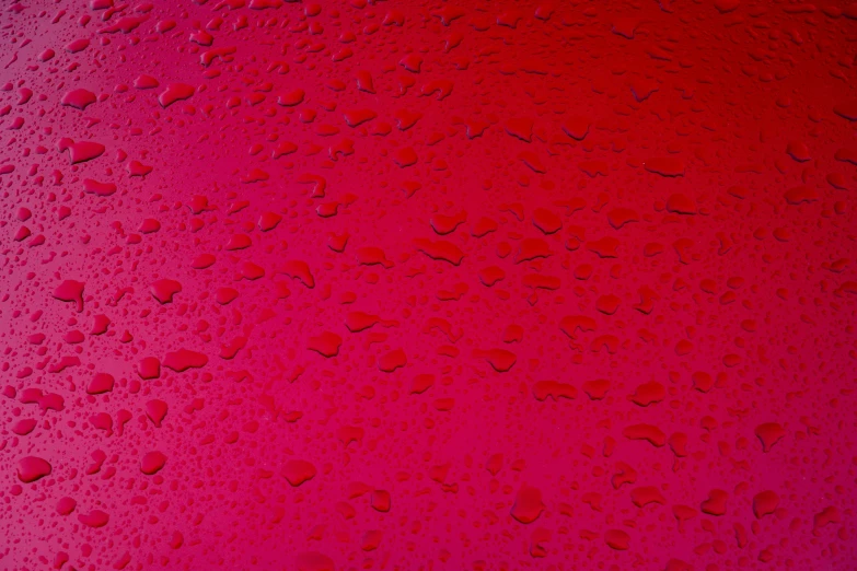 the droplets on the surface are red, pink and black