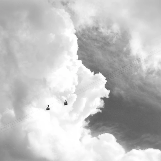 two paragliders flying through the air on power lines