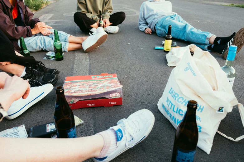 group of people sitting in a circle with drinks and beer