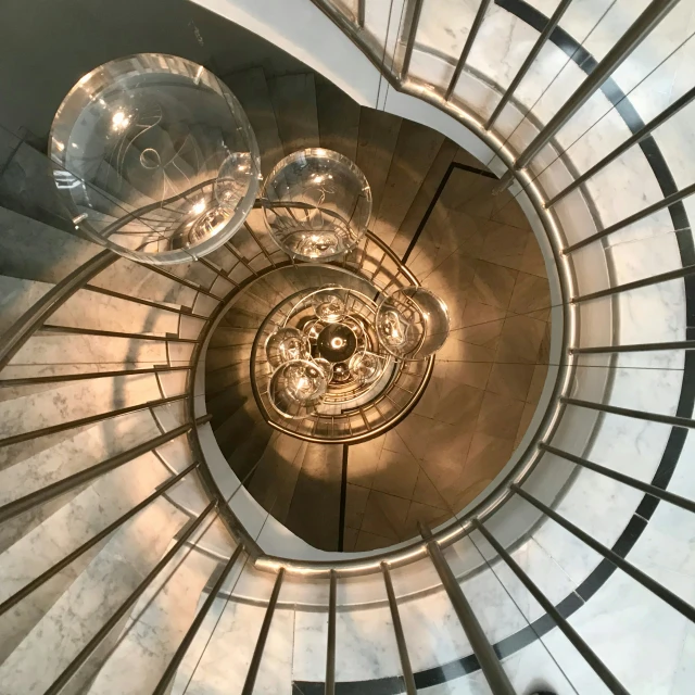 the top of a spiral staircase in an art museum