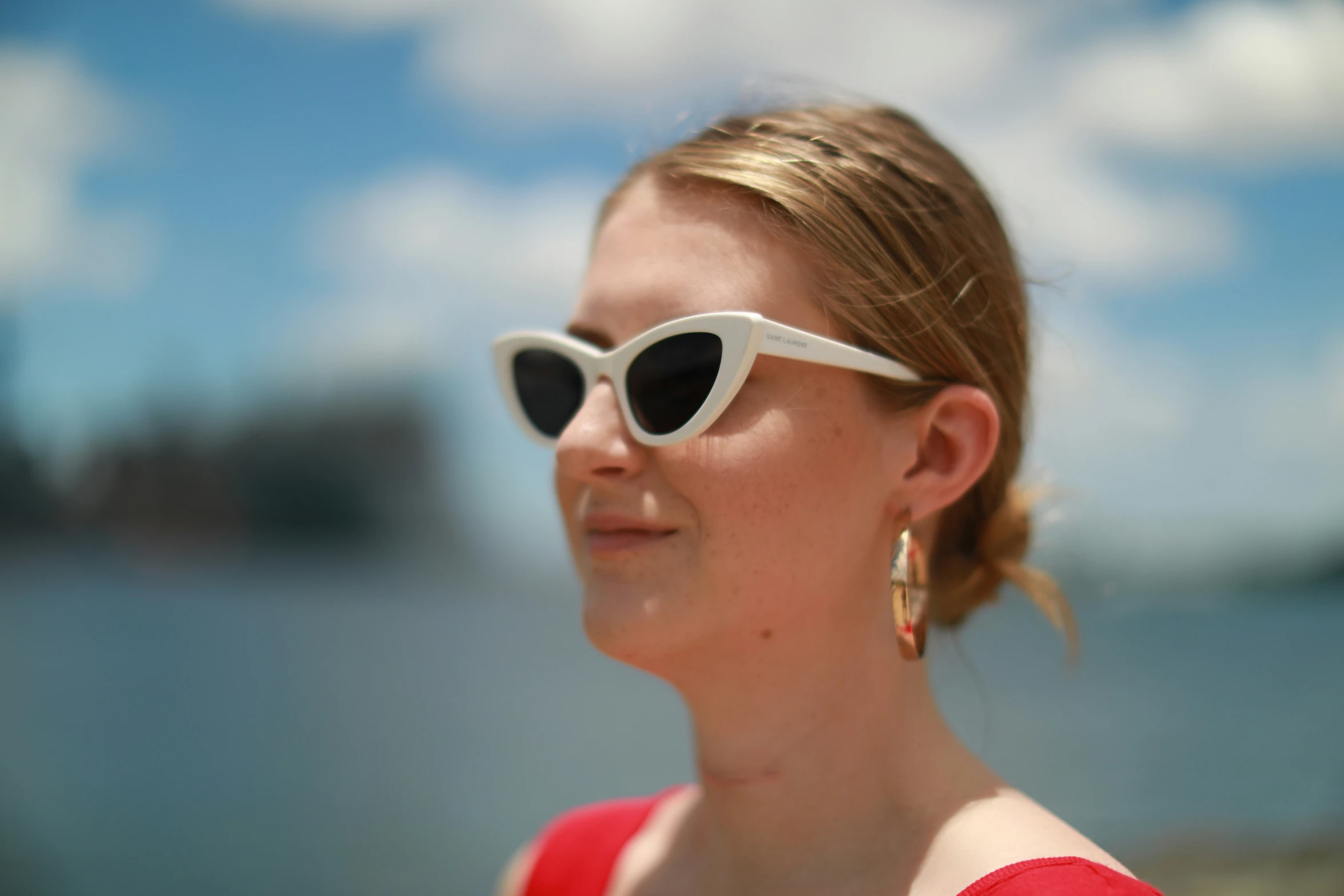 a beautiful young woman with sunglasses looking at the sky