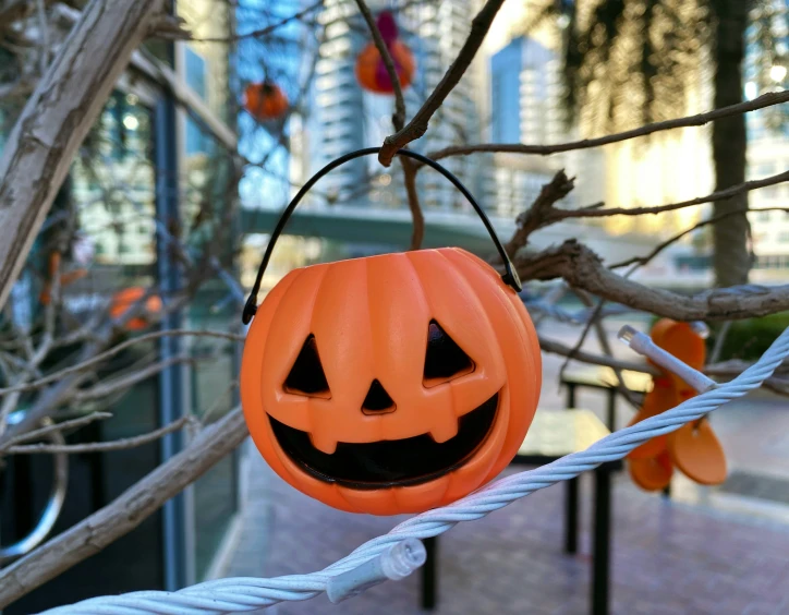 a jack - o'lantern shaped plastic hanging from a wire