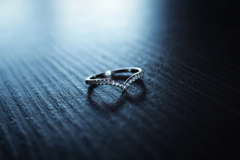 the wedding rings are laying on the wooden table