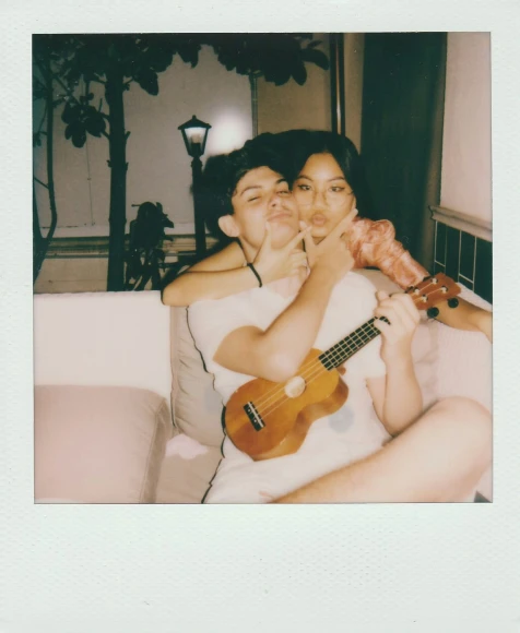 a man and woman sitting down with a guitar