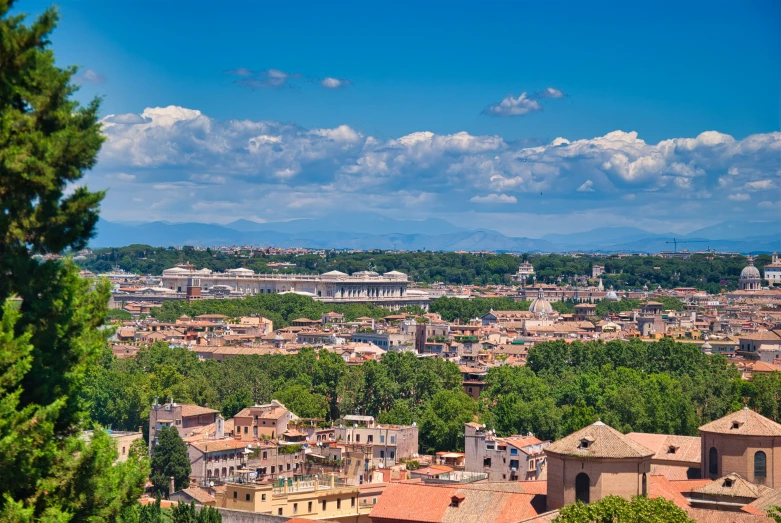 city surrounded by mountains and trees with blue sky