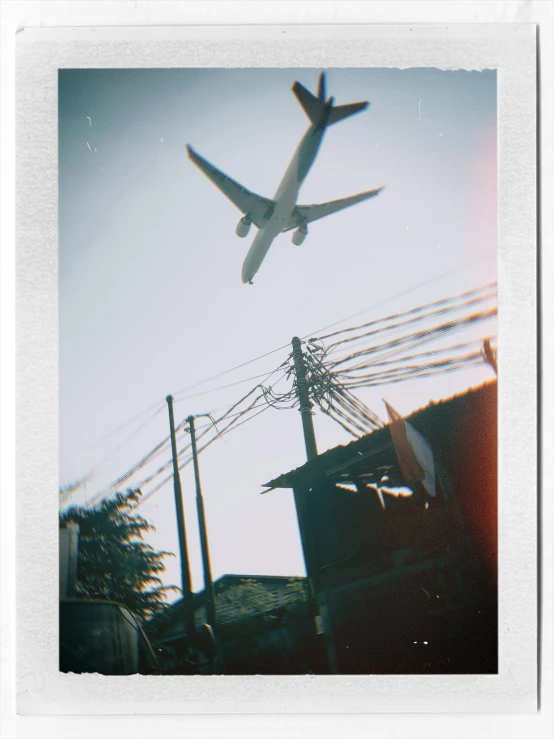 a large plane flies through the sky above power lines