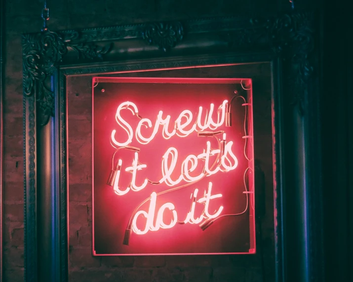 a neon sign that is hanging up on a wall