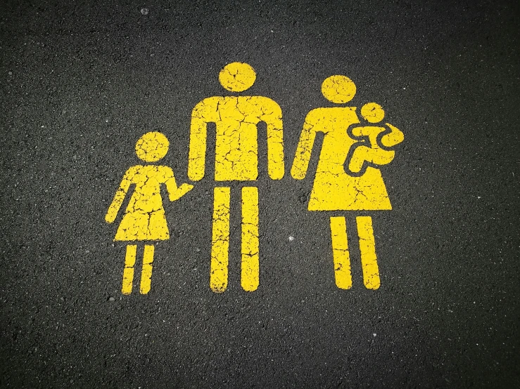 a yellow family on black pavement with red dots