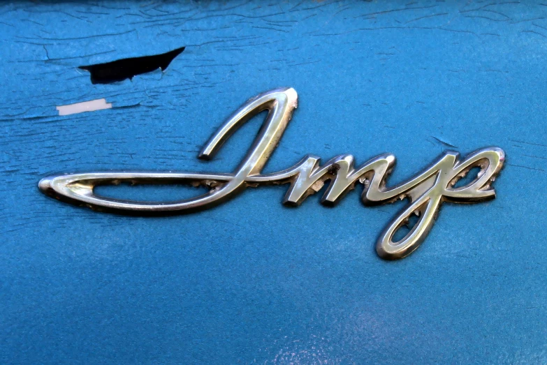a fancy metal nameplate sitting on the side of a blue car