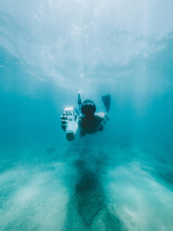 a person diving over a boat in clear blue water