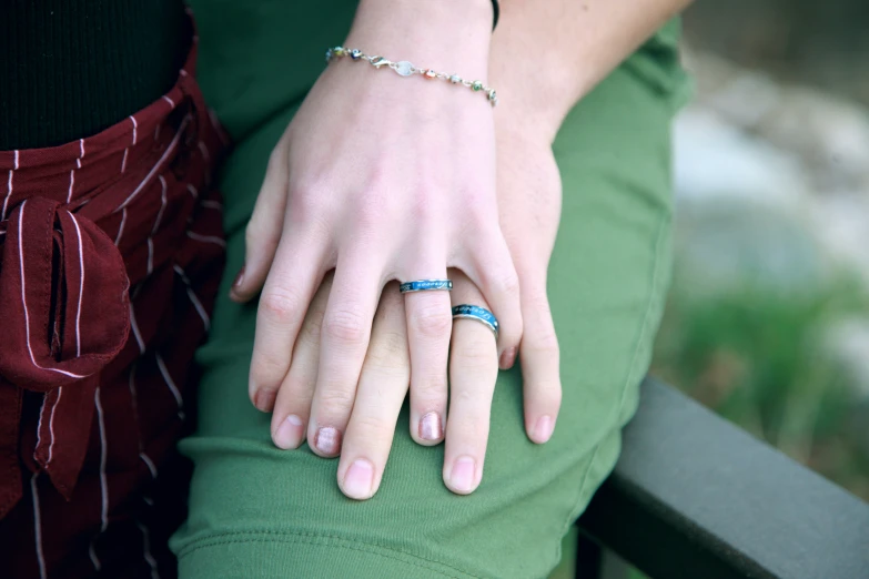 two people who are sitting down holding hands