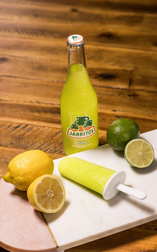 there are three lemons, a lime, and a bottle of garnto's on this board