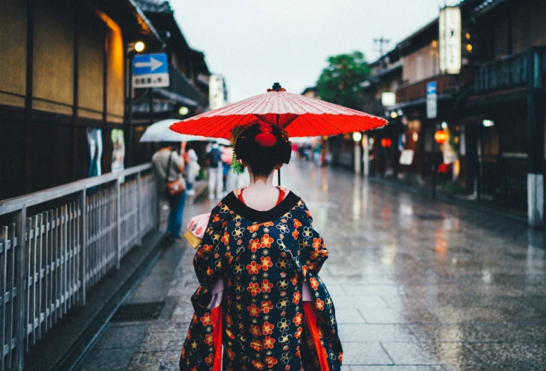 a woman is holding an umbrella and walking in the rain