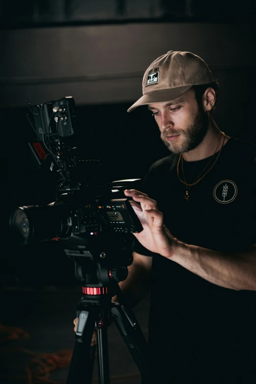 a man standing in front of a camera holding a cell phone