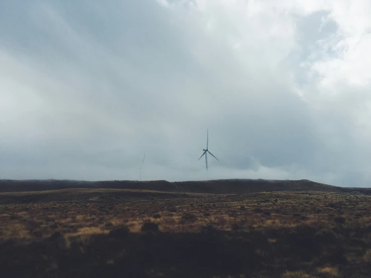 some wind mills on a very cloudy day