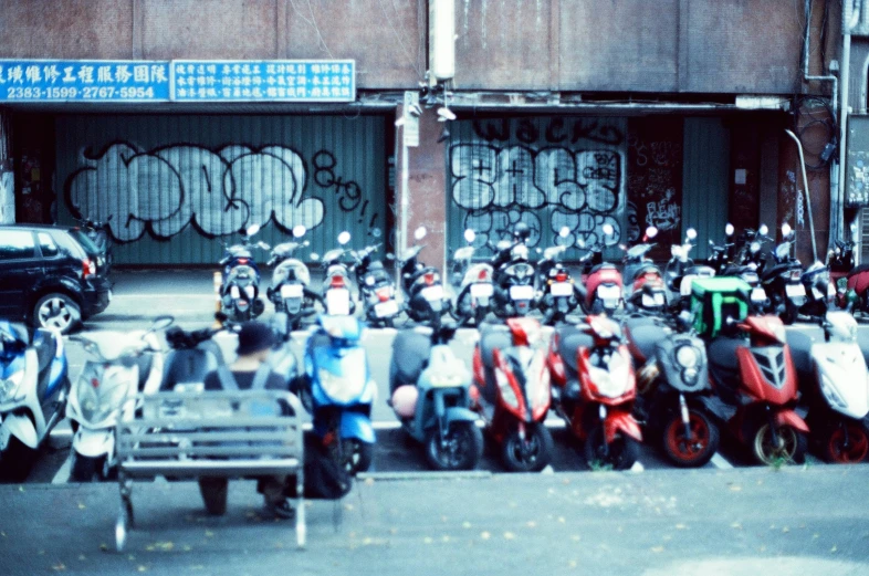 motorcycles are parked in front of buildings with graffiti on them