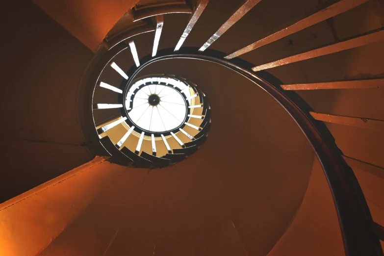 a very tall pretty wooden and glass spiral staircase