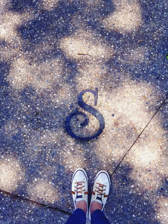 a person standing on the sidewalk next to the sign