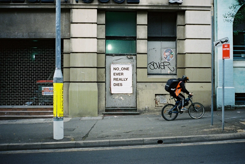 a bike rider stops in front of an old building