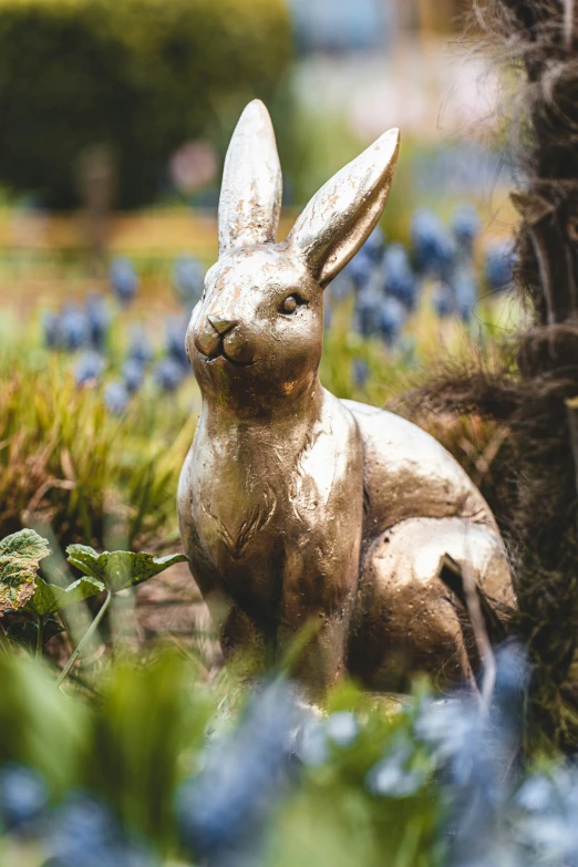 a garden decoration of a rabbit sitting in grass