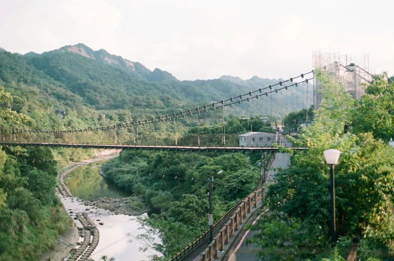 a bridge over a river and surrounded by hills