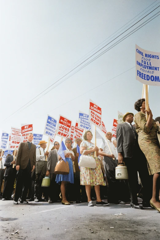 a large crowd is marching down the street holding up signs