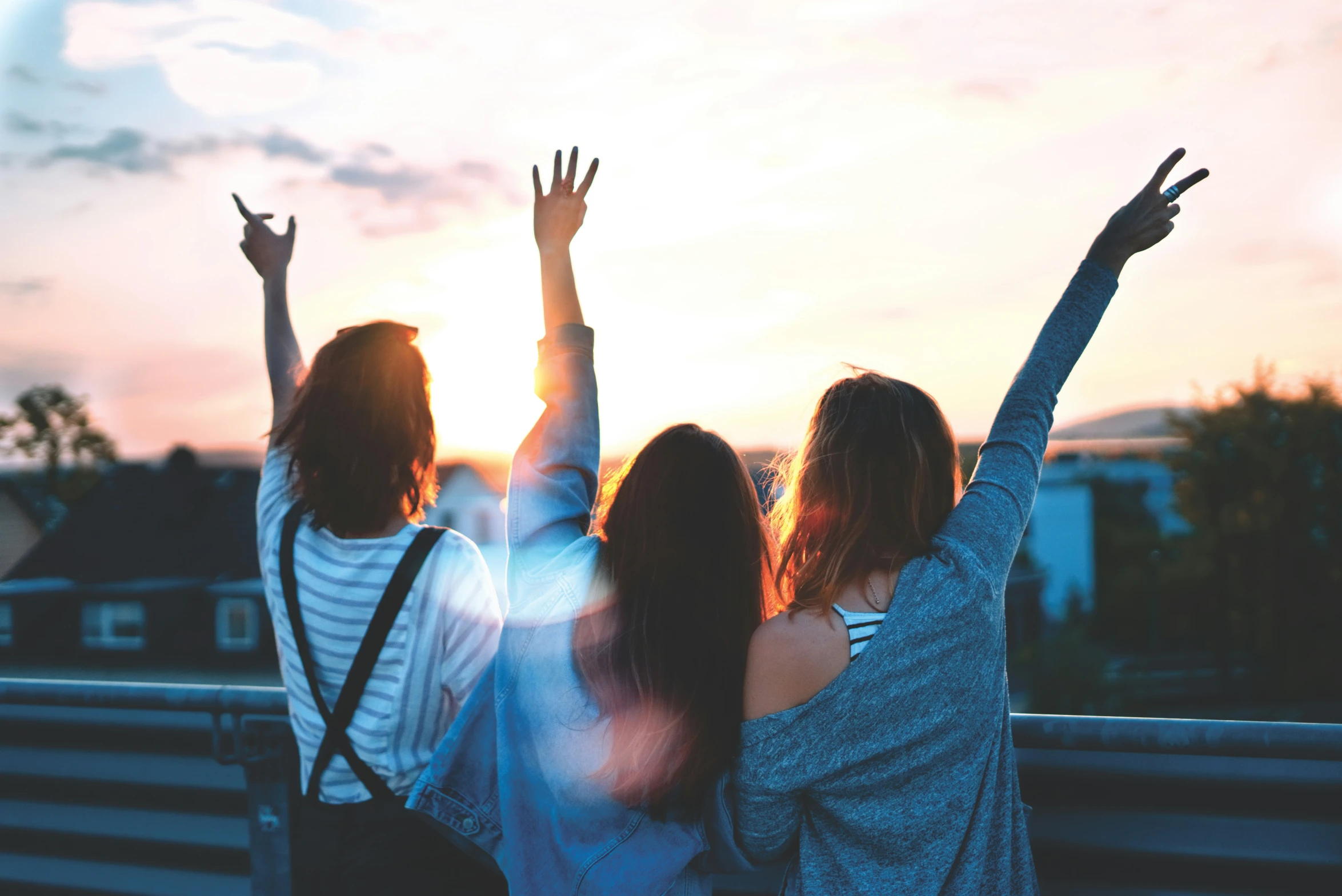 two women are standing together and arms raised