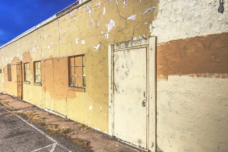 an old run down building that has been painted white and yellow