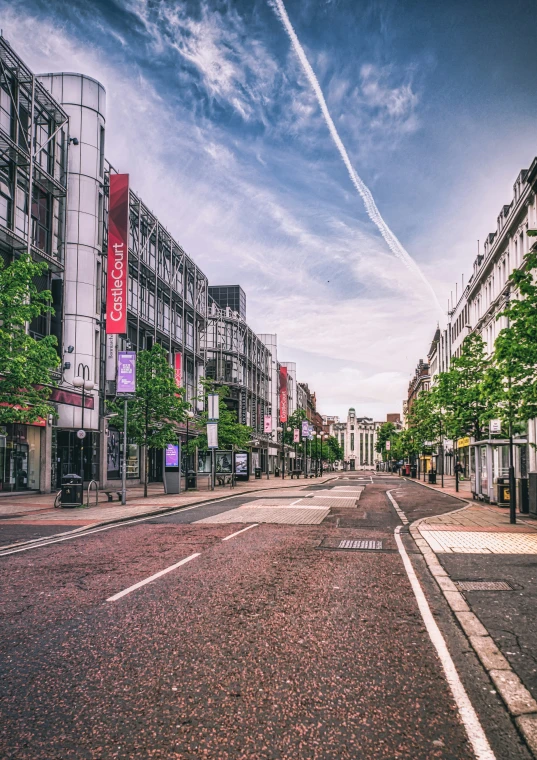 a city street lined with parked cars and tall buildings