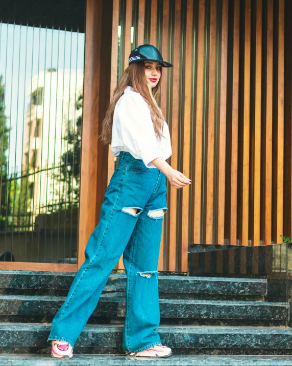 a young woman standing on steps with her hand in her pockets