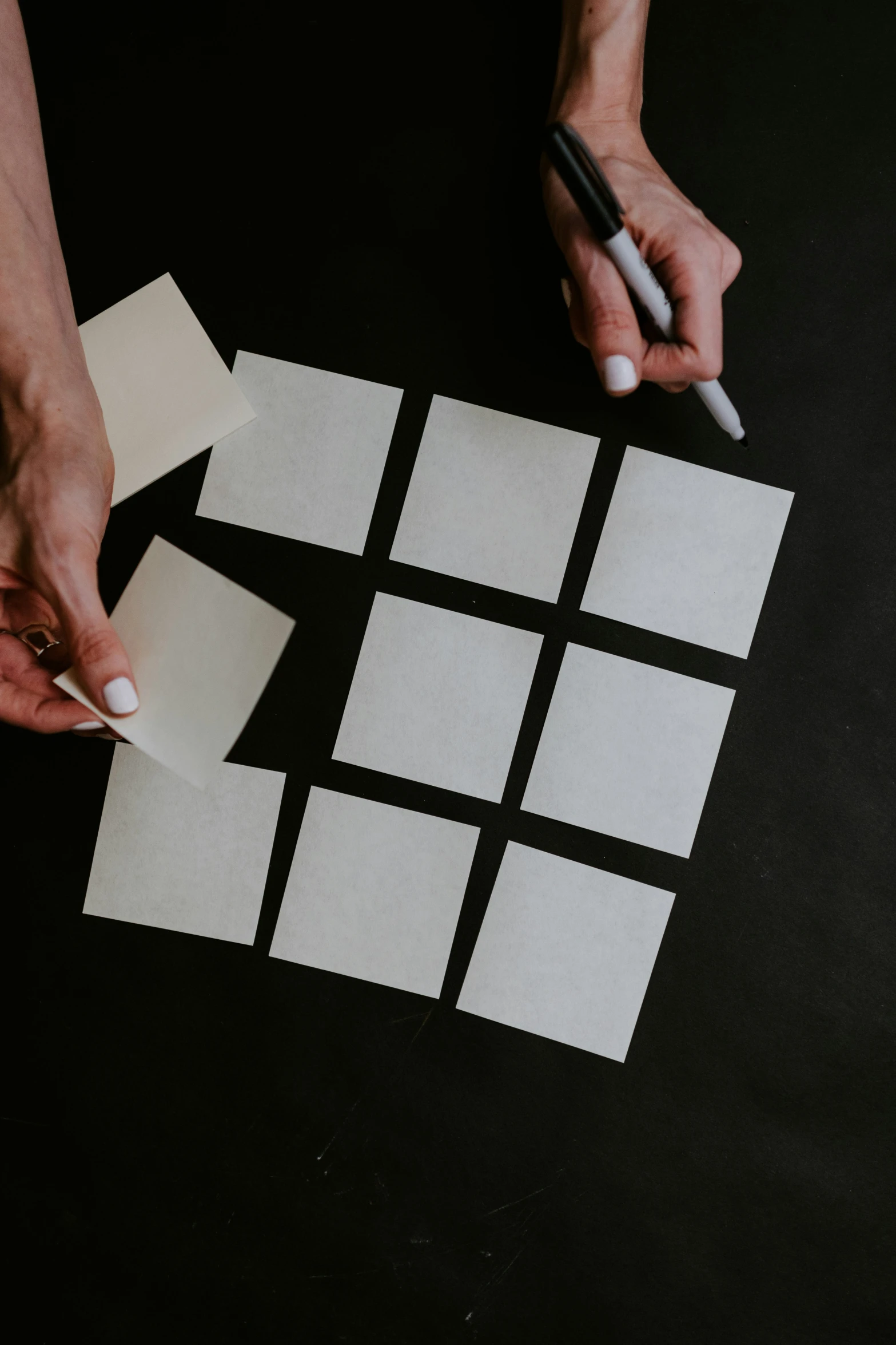 a person holds a white piece of paper as they cut a rectangle