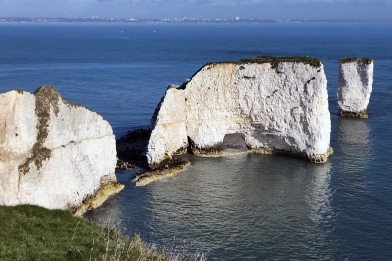 four rocks standing out in the water by the coast