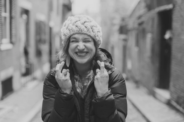 a woman with a large smile on her face wearing a knitted hat